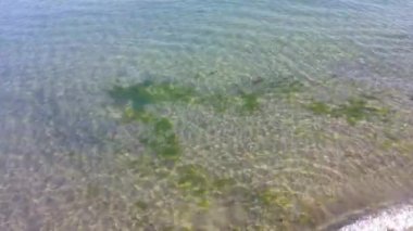 Dalgalanan berrak deniz suyunun doğal arka planı. Aquamarine deniz yüzeyinin havadan görünüşü. Sert deniz dokusu. Kopyalama alanı olan deniz teması.