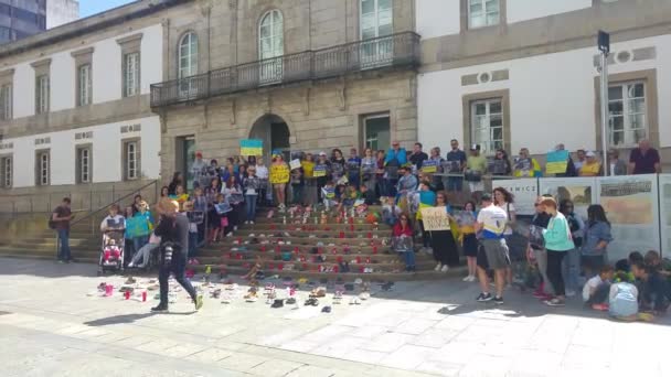 2022年4月30日 西班牙维戈 乌克兰人站在沉默的宣言上 反对俄罗斯占领者杀害乌克兰儿童 数以百计的鞋子在台阶上作为被谋杀儿童的象征 — 图库视频影像