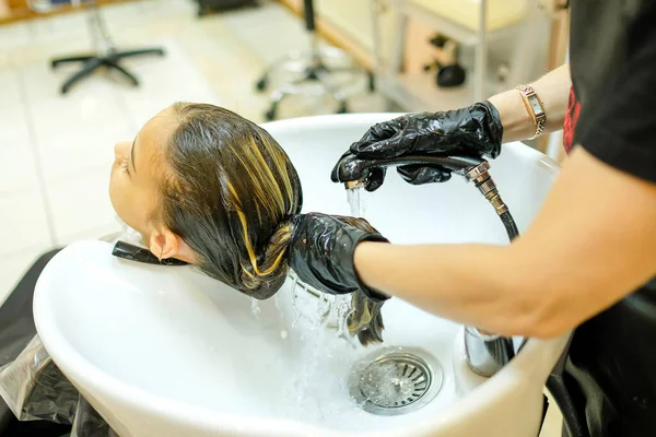 Una Chica Con Cabello Oscuro Lava Pelo Una Peluquería Imagen De Stock