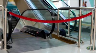 Alışveriş merkezinde kırmızı bantlı yürüyen merdiven. Otomatik merdivene giden yol kapalı. Şehir tecridi