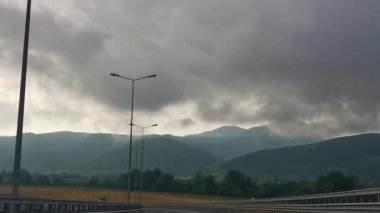 descent on the free highway, without cars. view of mountains and rain clouds