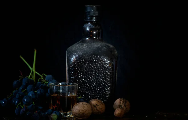 Dusty Bottle Brandy Glass Brandy Some Walnuts Grapes Black Background — Stock Photo, Image