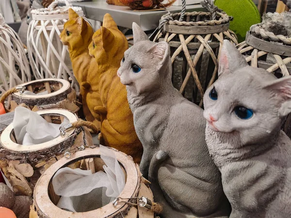 Ceramic cat souvenir shop. Cat figurines. home decorations. red and gray ceramic cats among the vases. the cat symbol