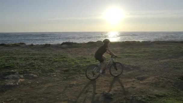 Frau radelt am Meer, Luft bei Sonnenuntergang — Stockvideo