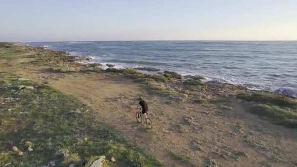 Kobieta na rowerze nad morzem, Aerial o zachodzie słońca — Wideo stockowe