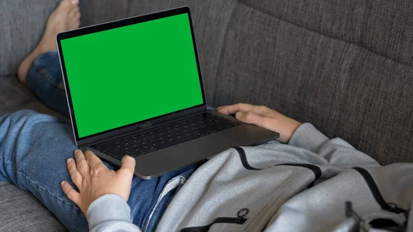 Man Watching a Green Screen Laptop on a Sofa — Stock Photo, Image