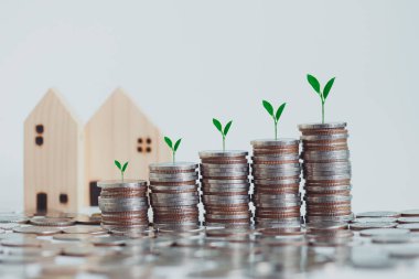 Büyüyen finansal ve iş için para biriktiriyorum. Tasarruf ve Hesaplar, Finans Bankası İş Konsepti, Yatırımlar, Fonlar, Faiz, Madeni paraların üzerinde büyüyen fabrikalar ve Ev.