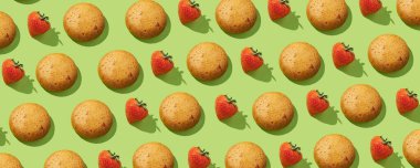 Çilek proteini kurabiyeleri yeşil pastel arka planda taze çilek desenli. Şekersiz. Üst Manzara. Proteinli ve bayat sağlıklı ve lezzetli kurabiyeler. Sürekli desen, izole, düz döşeme, sert ışık, asgari