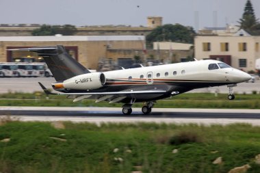 Luqa, Malta - 7 Kasım 2021: Flexjet Embraer EMB-550 Miras 500 (Reg. : G-MRFX) Gün batımından sonra 13. piste iniyor.