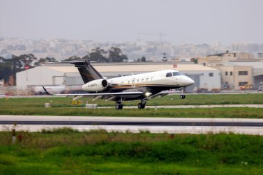 Luqa, Malta - 7 Kasım 2021: Flexjet Embraer EMB-550 Miras 500 (Reg. : G-MRFX) Gün batımından sonra 13. piste iniyor.