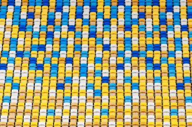 Bulanık pervaneler futbol stadyumunun arka planında plastik sandalyeler boyadı. Stadyumdaki sarı ve mavi koltuklara yakın çekim. ArenaLviv Ukrayna.