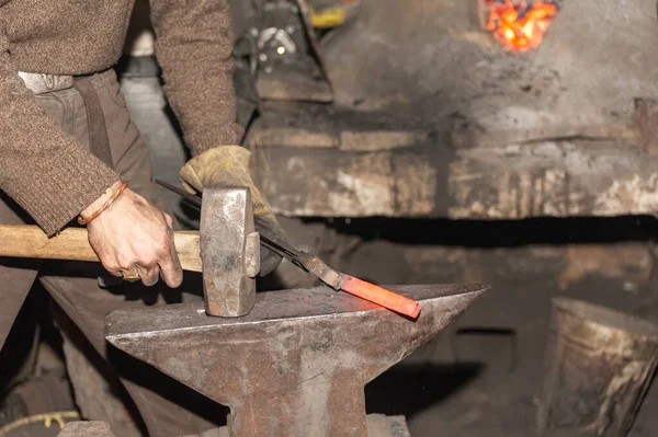 铁匠用铁锤在铁锤上锻造金属 — 图库照片