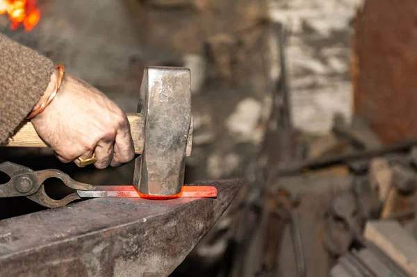 鍛冶屋は鍛造場のアンビルにハンマーで金属を作業 — ストック写真