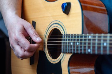 Müzisyen akustik gitar çalar. Müzisyen eli yakın plan.