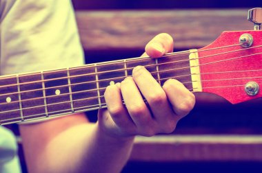Müzisyen akustik gitar çalar. Müzisyen eli yakın plan.