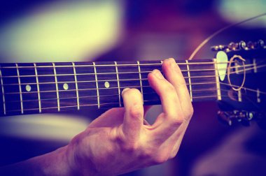 Müzisyen akustik gitar çalar. Müzisyen eli yakın plan.