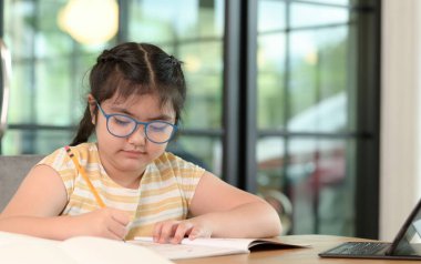 Asyalı kızlar evde ders veriyor, evde internet üzerinden çalışıyor, kızlar ders çalışmaktan sıkılmış ve yorulmuş..