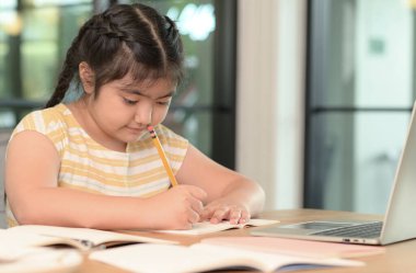 Asyalı kızlar evde ders veriyor, evde internet üzerinden çalışıyor, kızlar ders çalışmaktan sıkılmış ve yorulmuş..