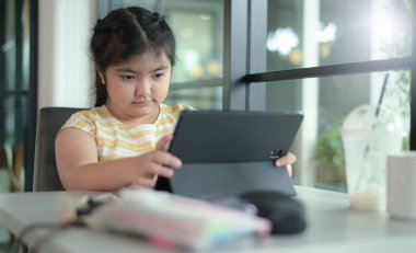 Asyalı kızlar evde ders veriyor, evde internet üzerinden çalışıyor, kızlar ders çalışmaktan sıkılmış ve yorulmuş..