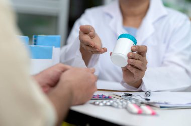 Hintli yaşlı kadın eczacı, beyaz erkek ilaçlarına hastalıkları tedavi etmelerini tavsiye ediyor, uzmanlar ilaç öneriyor, yakın çekim.