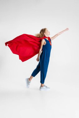 Kırmızı pelerinli güzel, beyaz bir kızın portresi. Gri stüdyo arka planında yürüyordu. Reklam için kopyalama alanı vardı.