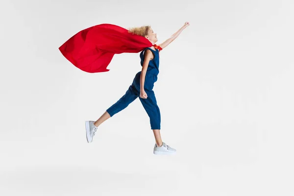 빨간 망토를 입고 서 있는 아름다운 코카서스 소녀의 모습, 광고를 위한 복사 공간 과 함께 회색 스튜디오 배경 위에서 고립된 채걷고 있는 모습 — 스톡 사진