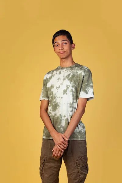 Πορτρέτο του νεαρού όμορφου αγοριού, μαθητής σε casual ρούχα χαμογελώντας απομονωμένος σε κίτρινο στούντιο backgroud. Αντίληψη ανθρώπινων συναισθημάτων. — Φωτογραφία Αρχείου