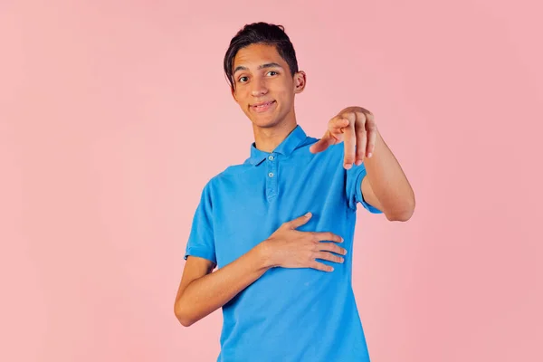 年轻男孩的前视图，身穿蓝色衬衫的学生在粉红工作室的背景图上摆出孤立的姿势。人类情感概念. — 图库照片
