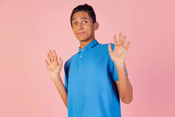 Retrato del joven adolescente, estudiante con camisa azul posando aislado sobre fondo de estudio rosa. Concepto de emociones humanas. — Foto de Stock