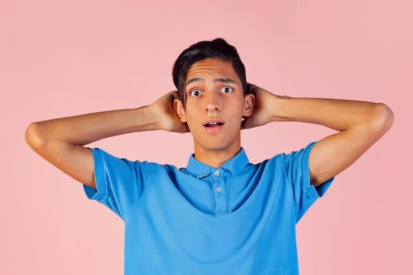 Πορτρέτο του νεαρού αγοριού, φοιτητής φορώντας μπλε πουκάμισο θέτουν απομονωμένο σε ροζ στούντιο backgroud. Αντίληψη ανθρώπινων συναισθημάτων. — Φωτογραφία Αρχείου