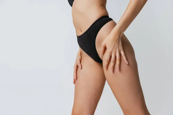 Belo corpo feminino fitness, pernas isoladas no fundo do estúdio cinza. Beleza natural, spa, conceito de tratamentos anti-celulite. — Fotografia de Stock