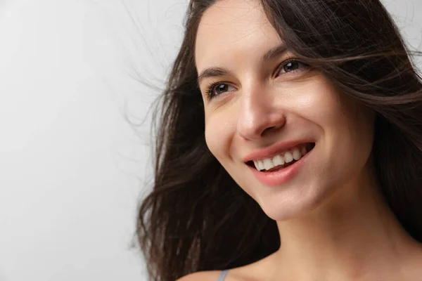 Close-up retrato de jovem bela mulher sorridente sem maquiagem isolada sobre fundo estúdio cinza. Conceito de beleza natural. — Fotografia de Stock