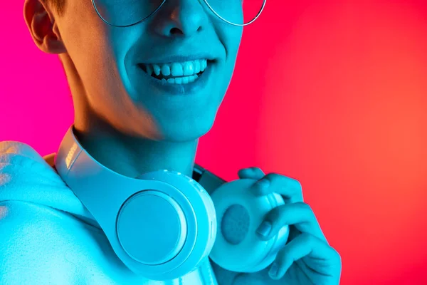 Imagem recortada de jovem estudante ou menino em roupas casuais sorrindo isolado no estúdio magenta backgroud em néon. Conceito de emoções humanas. — Fotografia de Stock