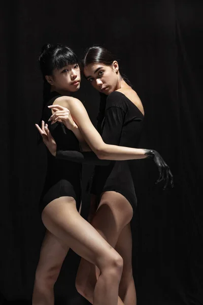 Modern bale gösterisi. İki güzel kız, karanlık arka planda soyutlanmış modern dansçılar. Duygular, duygular. — Stok fotoğraf