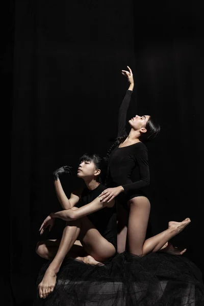 Современное балетное представление. Две красивые девушки, современные танцоры в художественном перформансе изолированы на тёмном фоне. Концепция чувств, эмоций — стоковое фото