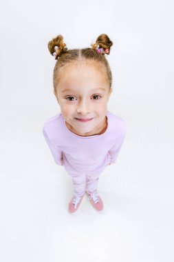 Kafamda saç telleri olan, beyaz stüdyo arka planında izole edilmiş modern şık kıyafetli güzel bir kızın yüksek açılı görüntüsü..