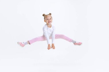 Beyaz arka planda izole bir şekilde atlayan komik, küçük, şirin, aktif Kafkas anaokulu kızı. Mutlu çocukluk kavramı