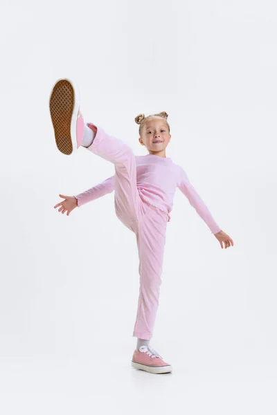 Vue du bas. Portrait de petite fille préscolaire blanche active marchant isolée sur fond blanc — Photo