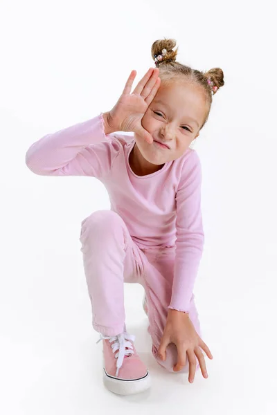 Кумедна маленька активна кавказька дошкільна дівчинка, що зображає себе ізольованою над білим фоном. Поняття щасливого дитинства — стокове фото