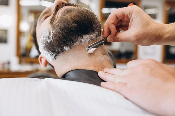 Un hombre que se corta el pelo en la peluquería. Peluquería profesional en el proceso de trabajo. Belleza, cuidado personal, estilo, moda, salud y cosméticos masculinos concepto. — Foto de Stock