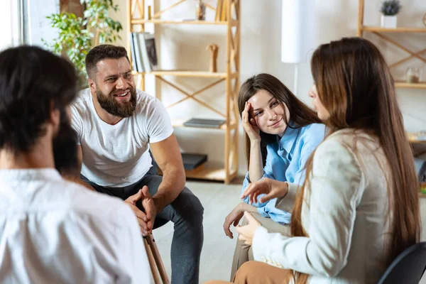 Jovens multiétnicos, homens e mulheres sentados juntos, conversando, se comunicam em grupo de apoio psicológico, dentro de casa. — Fotografia de Stock