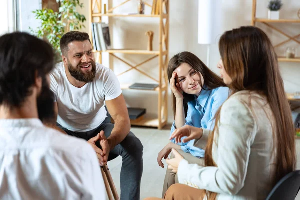 Jóvenes multiétnicos, hombres y mujeres sentados juntos, conversando, comunicándose en el grupo de apoyo psicológico, en interiores. —  Fotos de Stock