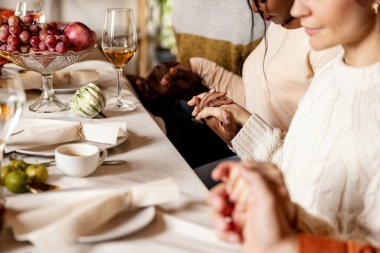 Şükran Günü 'nü mutlu bir aile kutluyor. Kızarmış hindi ve geleneksel bayram yemekleri ile masada oturuyorlar..