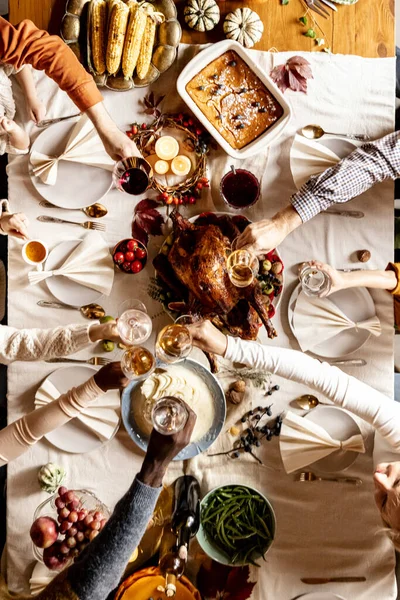 Blick von oben auf multiethnische Hände mit Weingläsern feiern Thanksgiving-Tag, festlich dekorierte Tafel mit gebratenem Truthahn und Feiertag traditionelle Speisen, Gerichte. — Stockfoto