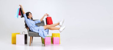 Kara Cuma satışlarından sonra mutlu ve güzel bir genç kız. Bir sürü çantalı model, beyaz stüdyo arka planında izole edilmiş renkli parlak paketler..