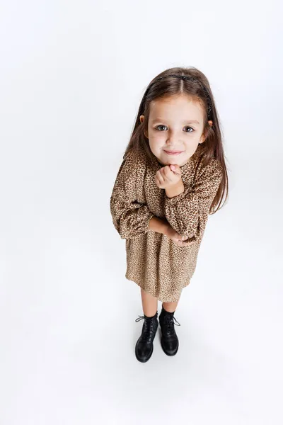 Vysoký úhel pohledu na malé roztomilé usmívající se školka krásná dívka při pohledu na kameru izolované přes bílé studio pozadí. — Stock fotografie