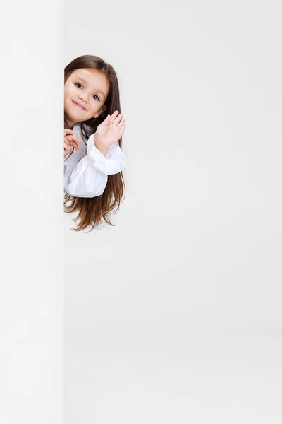 Jedna roztomilá krásná holčička hraje izolované na bílém pozadí studia. Lidské emoce, pojetí výrazu obličeje. — Stock fotografie