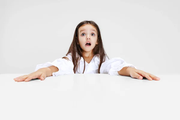 Retrato de beuatiful chica de la escuela sentado y mirando a la cámara aislada sobre fondo blanco. —  Fotos de Stock