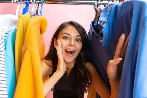 Hermosa chica joven elige ropa, equipo, vestido en la tienda de ropa. Wow emociones, viernes negro, lunes cibernético, compras, descuento, anuncio. — Foto de Stock