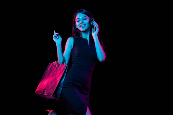 Portrét mladé ženy v neonovém světle na tmavém pozadí. Lidské emoce, černý pátek, kybernetické pondělí, nákupy, prodej, finanční koncept. — Stock fotografie